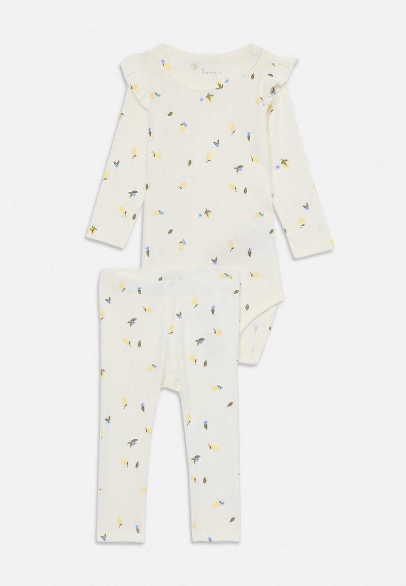 Vauvan puuvillapuku, jossa pitkähihaisessa bodysuitissa ja legginsseissä on kerma-pohja, jossa on keltaisia sitruunoita ja sinisiä kukkakuoseja. Rypytetty olkatyyny.