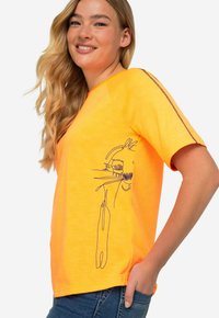 Feloranje T-shirt met korte mouwen, met een zwart lijntekeningontwerp aan de linkerkant. Zachte stof met een ontspannen pasvorm en contrasterende stiksels.