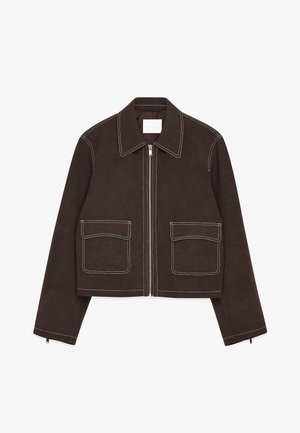 Brūns zamšādas apgrieztais žakets ar metāla rāvējslēdzēju, divām priekšējām kabatām, baltām šuvēm, ar ievēlētu apkakli un rāvējslēdzēja detaļām uz piedurknēm.