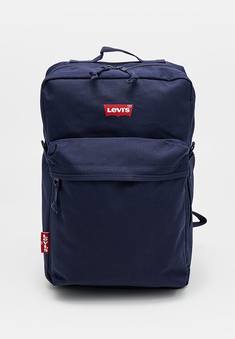 Mochila Levi's azul marino con bolsillo frontal con cremallera y logo rojo en la parte superior central y etiqueta lateral, en posición vertical sobre fondo liso.