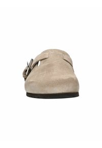 Beige suède instapper met een gladde textuur, ronde neus en een zijklep met een zilveren metalen accent. Platte rubberen zool.