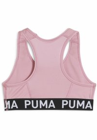 Roza športna modrček z teksturirano tkanino, designom z dirkaško hrbtno stranjo in črnim elastičnim pasom z belim besedilom "PUMA" na dnu.