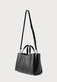 Czarna syntetyczna torebka z pikowanym wzorem jodełki, podwójnymi górnymi uchwytami oraz odpinanym, regulowanym paskiem. Prostokątny kształt o gładkiej fakturze.