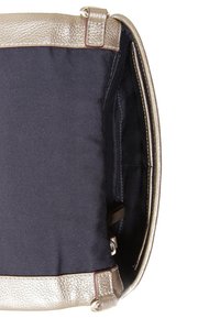 Kultainen teksturoitu käsilaukku, jossa on musta kangasvuori. Sisältää sisätaskuja ja rakenteellisen muodon, jossa on säädettävät metalliosat.