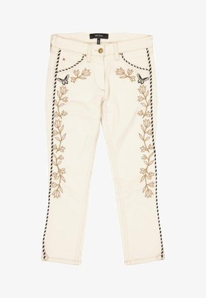 Pantalones color crema con bordado floral vertical y diseños de mariposas en la parte delantera, y ribete de rayas en blanco y negro en los costados.