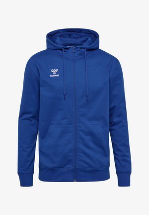 Blaue Reißverschluss-Hoodie aus einem weichen Stoff. Verfügt über eine Kapuze mit Kordelzug, zwei frontale Taschen und ein weißes Logo auf der Brust. Glatte Textur.