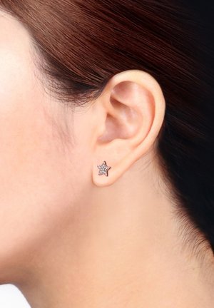 Boucle d'oreille en forme d'étoile en or rose avec des cristaux clairs incrustés, présentant une surface lisse et une finition poli.