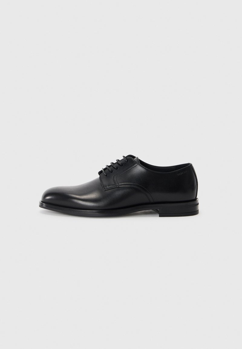 Chaussure habillée en cuir noir avec un bout arrondi, un lacet, une texture lisse et une semelle en caoutchouc basse. Détails de couture minimaux.