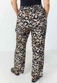 Leopardprint, lichte broek met een elastische tailleband, wijde pijpen en een gladde textuur. Heeft tinten beige, zwart en bruin.