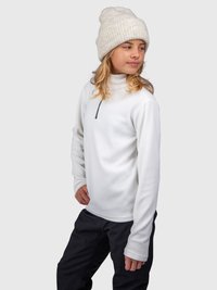 Giovane che indossa un pullover bianco in pile con mezza zip, pantaloni neri e un berretto di maglia beige, che guarda di lato.
