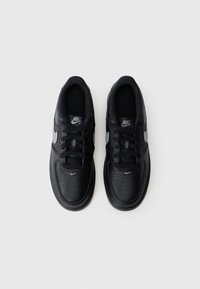Crne Nike Air tenisice s kožnim gornjim dijelom, okruglim završetkom, perforacijama za prozračnost, crnim vezicama i sivoj Swoosh oznaci na strani.