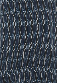 Marineblaues Material mit einem Blattmuster in Blau und Weiß. Die Blätter sind in einem sich wiederholenden, symmetrischen Design angeordnet, das starke Kontraste und visuelles Interesse schafft.
