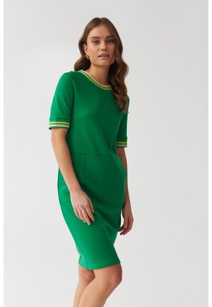 Robe verte à manches courtes avec un col rond, présentant des détails rayés contrastants sur les manches et une silhouette ajustée avec des poches latérales.