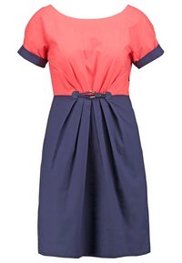 Robe color-blockée corail et marine avec des manches courtes, jupe plissée et une ceinture décorative à la taille. Fabriquée en tissu léger.