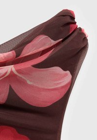 Tissu brun transparent avec de grands motifs floraux roses, présentant une texture légèrement froissée et un détail froncé le long du bord supérieur.