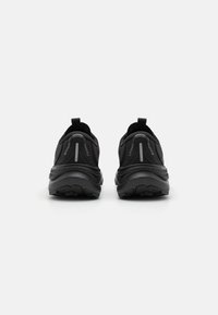 Zwarte sport schoenen met een ademend mesh bovenwerk, een gevoerde zool en reflecterende accenten. Heeft een lus aan de hak voor gemakkelijk aan- en uittrekken.