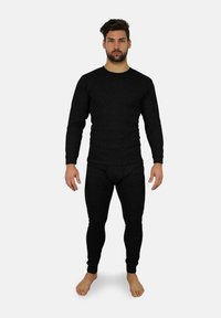 Schwarzes langärmliges Thermo-Oberteil und -Unterteil-Set aus geripptem Stoff, mit Rundhalsausschnitt und figurbetonter Silhouette, getragen von einem Modell.