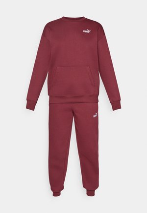 Sweatshirt bordeaux à col rond, manches longues et poche avant, associé à un pantalon assorti. Présente un petit logo Puma blanc sur les deux.