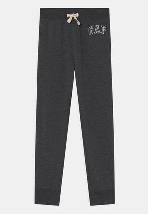 Pantalon de survêtement gris foncé avec taille élastique, cordon beige, jambes fuselées et logo blanc GAP sur le haut de la cuisse gauche.