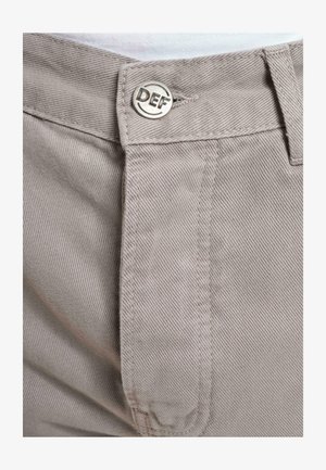 Pantaloni din bumbac gri deschis, cu un model texturat, închidere cu fermoar și un buton rotund argintiu inscripționat cu "DEF", și un design frontal plat.