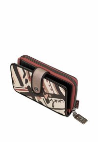 Cartera hecha de tela estampada con un diseño en beige y negro, con un interior rosa, cierre de cremallera y botón a presión con un charm metálico.