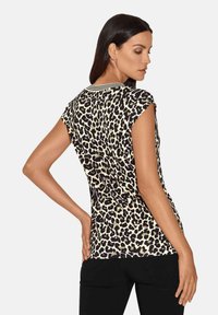 Leopardenprint T-shirt in crème en zwart, met capmouwen en een gestreepte halslijn. Zachte stof met een getailleerde pasvorm.