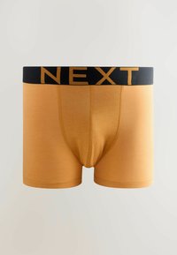 Boxeri scurți pentru bărbați de culoare muștar, cu un brâu negru pe care este inscrit cu litere mari cuvântul NEXT.