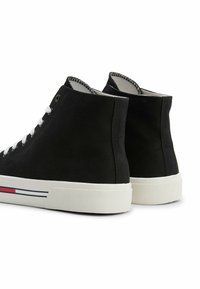 Czarne trampki wysokie wykonane z płótna, z białymi sznurowadłami, białą gumową podeszwą oraz czerwonymi i niebieskimi paskami akcentującymi po bokach.