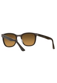 Occhiali da sole in plastica marrone con forma quadrata, lenti sfumate e dettagli metallici sulle tempie. Presentano una finitura elegante e lucida.
