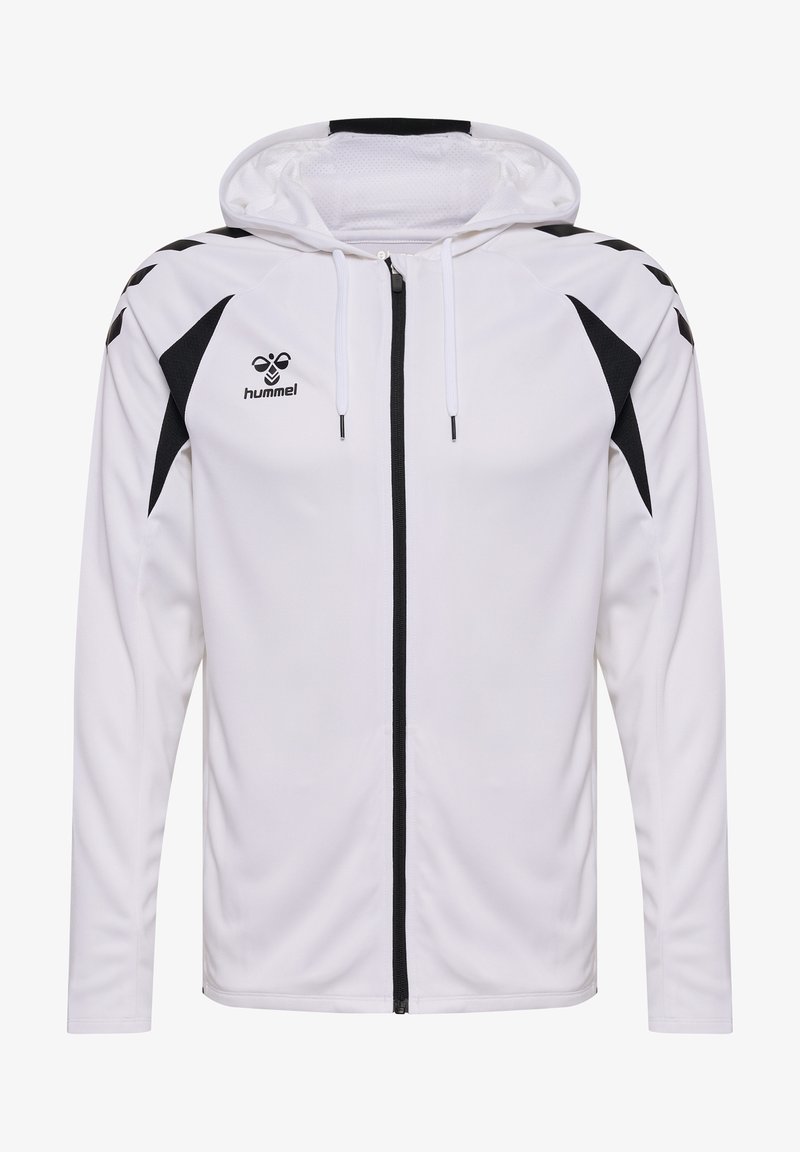 Veste blanche à capuche avec fermeture éclair, motifs chevrons noirs sur les épaules et panneaux noirs sous les manches, style sport.