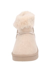 Botín de ante beige hasta el tobillo con un suave puño de pelo sintético, punta redondeada y suela de goma texturizada. Detalle de cordones en la parte trasera.