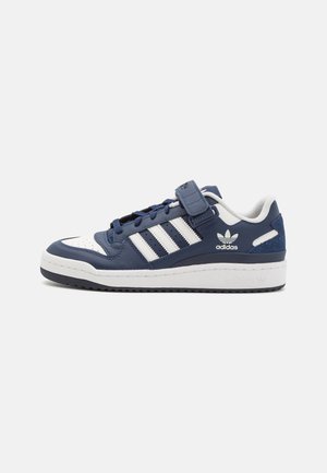 Low-Top Adidas Sneaker in Marineblau und Weiß mit drei weißen Streifen, Klettverschluss und Gummisohle.