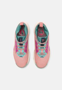 Une paire de chaussures de sport roses et turquoise avec des lacets à motifs, un col rembourré et des logos visibles sur les semelles intérieures et les languettes, montrées de dessus.