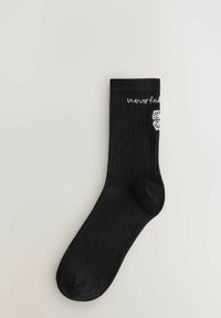 Crne rebraste čarape s bijelim natpisom "neverfull" i složenim uzorkom sa strane. Bezšavni prst i mekana tekstura.