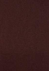 Tissu tricoté marron foncé avec une texture fine et douce, et un ourlet côtelé le long du bord inférieur.