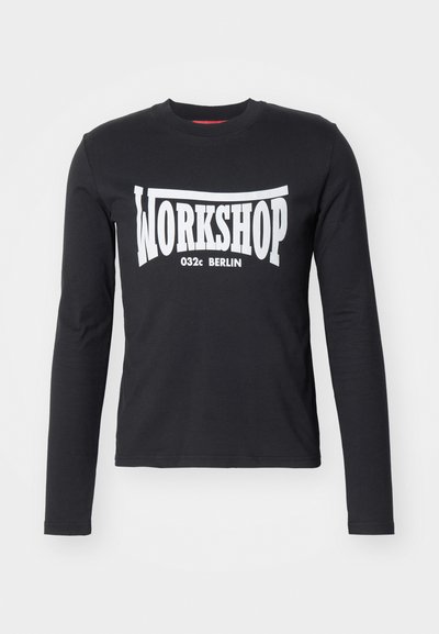 Μαύρο μπλουζάκι με μακριά μανίκια από βαμβάκι, με μεγάλη λευκή γραφική παράσταση "WORKSHOP 032c BERLIN" στο μπροστινό μέρος. Λείο υλικό, στρογγυλή λαιμόκοψη.