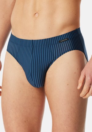 Men's swim briefs, featuring a vertical stripe pattern in dark blue and lighter blue. Elastic waistband with logo detail, smooth texture.