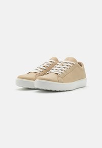 Sneakers in pelle beige con lacci e suola bianchi; design a profilo basso; parte superiore texturizzata; punta rotonda liscia; branding discreto sul lato.