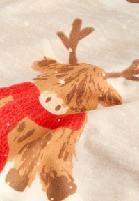 Hladký sob so červeným šálom s bielymi snehovými vločkami na svetlo béžovom textúrovanom pozadí.