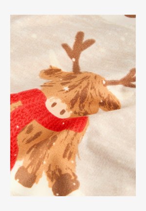 Fluffy reindeer wearing a red scarf with white snowflakes on light beige textured fabric background.
