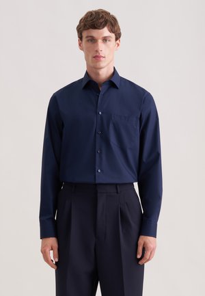 Donkerblauw overhemd met lange mouwen, gemaakt van gladde stof, voorzien van een spitse kraag, knopen aan de voorkant en een enkele borstzak. Getailleerde pasvorm.