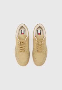 Tan leather sneakers with perforated detailing, rounded toe, beige lining, and contrasting blue accents. Features lace-up closure and logo tag.