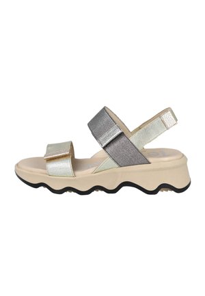 Sandalias con tiras metálicas que presentan una suela beige con un borde ondulado, acentos en plata y oro, y una correa en el talón ajustable. Detalles de tela texturizada.