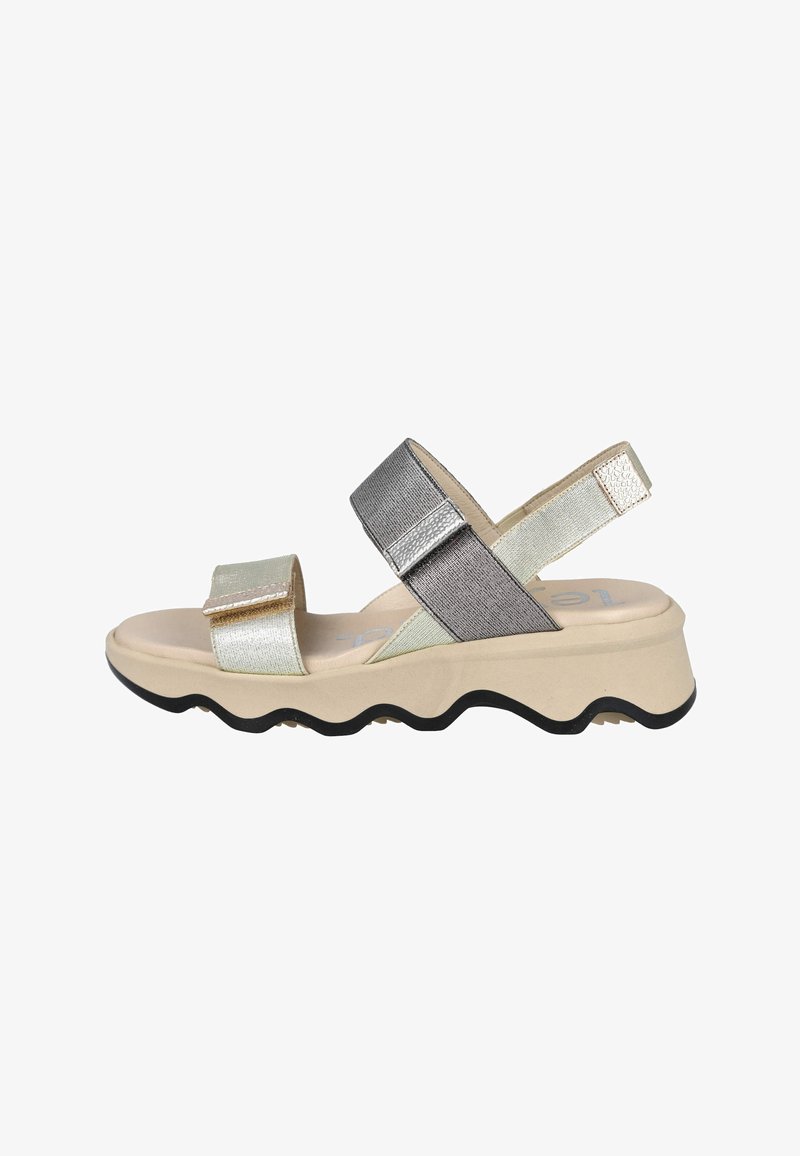 Sandalias con tiras metálicas que presentan una suela beige con un borde ondulado, acentos en plata y oro, y una correa en el talón ajustable. Detalles de tela texturizada.