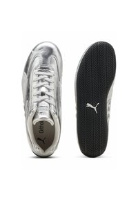 Baskets Puma avec une tige argentée métallique, des accents blancs et une semelle texturée noire. Dotées d'un design à lacets et du logo sur la languette.