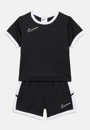 Schwarz-weißes Nike-Kurzarmshirt für Kleinkinder und passende Shorts mit Swoosh-Logos auf Brust und Bein.