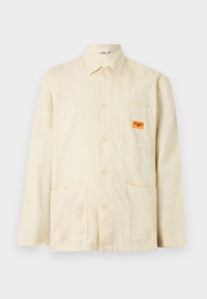 Kremowa, zapinana na guziki kurtka z długim rękawem z trzema naszywanymi kieszeniami z przodu, w tym jedną z pomarańczową etykietą "Service Worker".