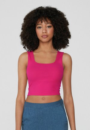Tvarovaný, žebrovaný cropped top v jasně růžové barvě se čtvercovým výstřihem a širokými ramínky. Kombinováno s džíny s vysokým pasem.