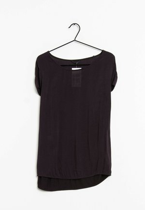 Blouse noire à manches courtes avec encolure ronde et dos légèrement plus long, suspendue à un cintre métallique noir sur fond blanc.