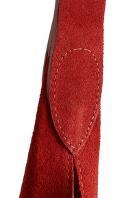 Red suede material with a soft texture. Features a stitched edge and a rounded suede patch detail. Shape is tapered toward the top.